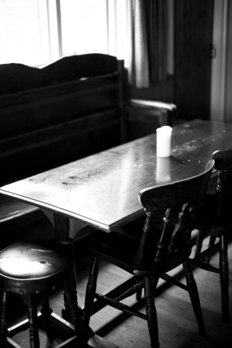 Detail of an old pub table next to a window in black and white