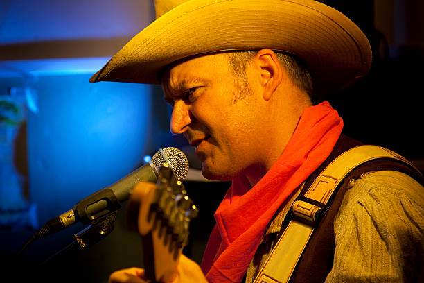istock Cowboy playing guitar and singing into microphone 182417862