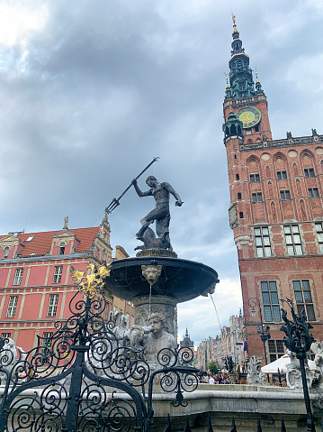 Gdansk Poland - July 16, 2023 Visitors leisurely wander through Gdańsk's Old Town in Poland, meandering past the renowned Neptune Fountain and the majestic Danzig City Hall.