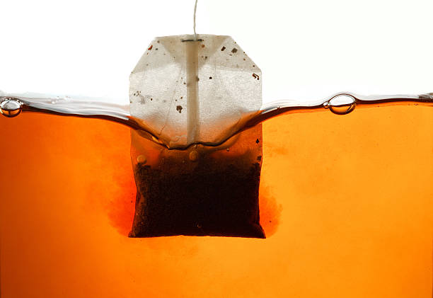Teabag in hot water my new photos with teabag: black tea stock pictures, royalty-free photos & images