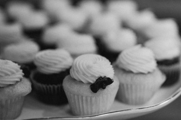 istock Array of cupcakes adorned with white frosting in grayscale 1824186982