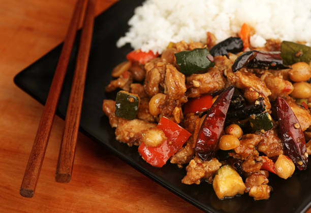 istock Kung Pao Chicken, white rice, chop sticks on a black plate 182418711