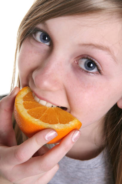 istock Girl Eating Orange 182418720