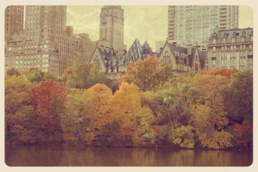 Retro-styled postcard of the colorful autumn trees along Central Park West in New York City. In the background is The Dakota -- a co-op apartment building located on the northwest corner of 72nd Street and Central Park West in the Upper West Side of Manhattan -- the location of the murder of John Lennon.