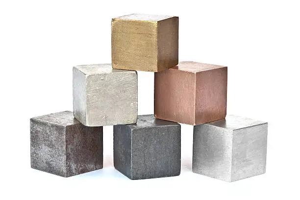 "Six common metals imaged on white card. From left to right, bottom row iron zinc aluminum, middle row tin copper, top row brass. Shadow perspective cast by the blocks fades to a pure white background. There are companion images:"