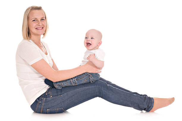 Mother in white clothes play with her baby isolated on white