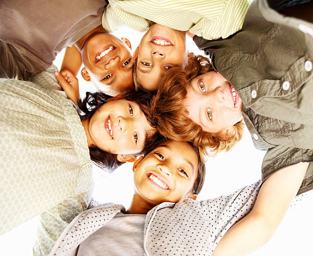 istock Five children in a huddle smiling down at camera 182419501