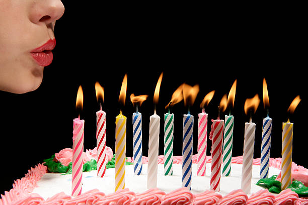 Vibrant colored abstract birthday cake with candle glowing