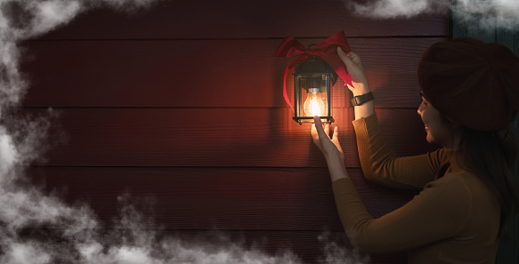 Christmas girl decorating lanterns at night Background image.