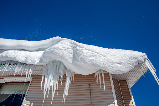 Snow mass and icicles hanging from the roof