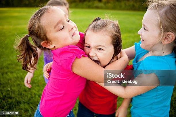 Happy Young Girls Abrazándose Y Riéndose Juntos Al Aire Libre Foto de stock y más banco de imágenes de Jugar a luchar