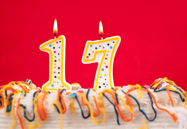 istock Decorated birtday cake with number 17 candles.  Red background 182420700