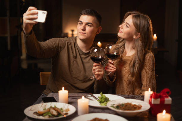 istock Young couple in love taking selfie while having dinner at home or in restaurant, celebrating valentine's day, enjoying time spent together 1824207436