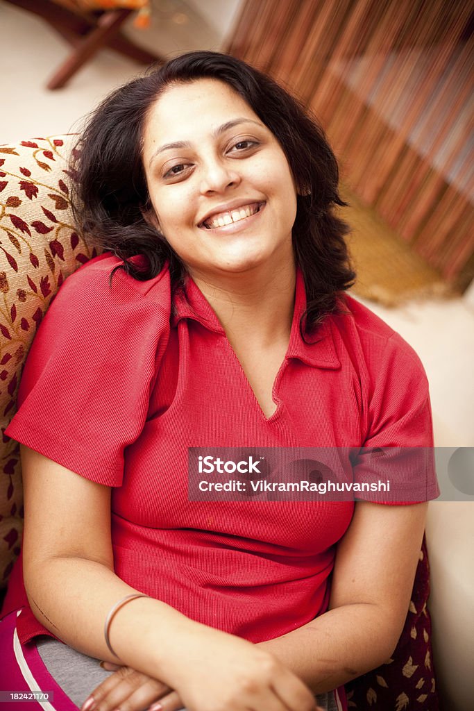 Alegre India mujer relajante en su casa por placer, vertical - Foto de stock de 30-39 años libre de derechos