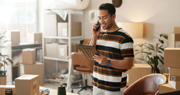 istock Man, phone call and boxes for online logistics, startup communication and small business courier on tablet. Entrepreneur or seller talk on mobile, digital technology and package for e commerce order 1824212701