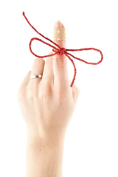 "Female Hand With Red String On Indexfinger, isolated on white."