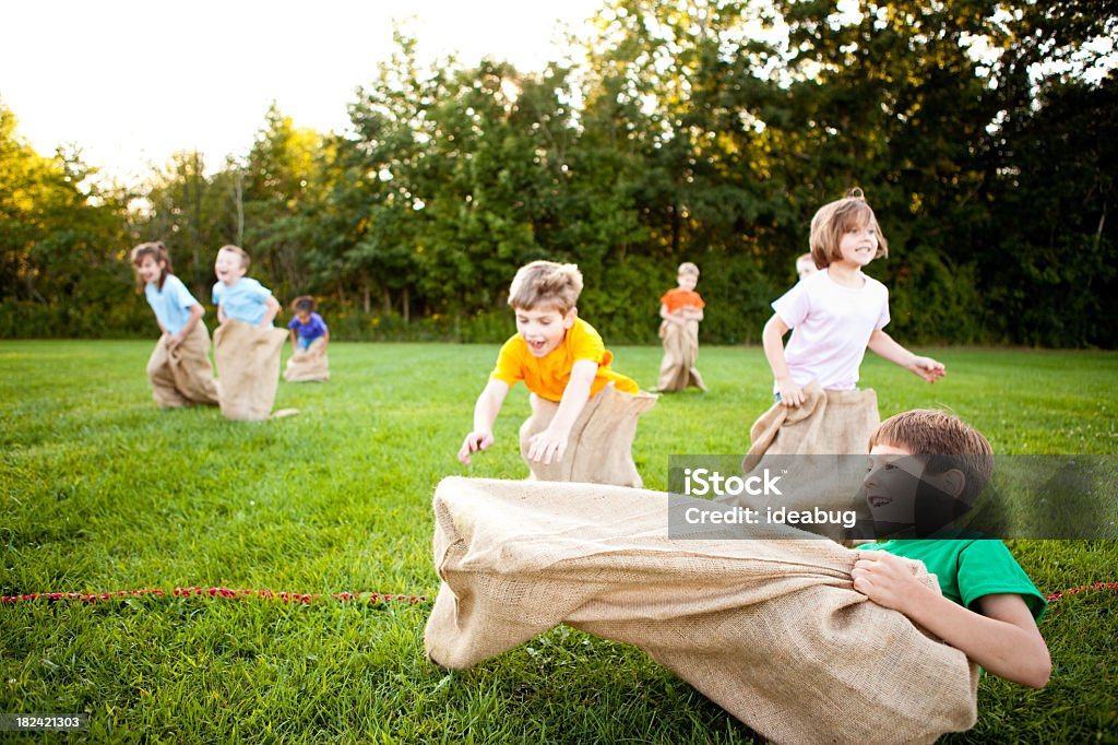 Heureux enfants ayant une Course en sac de pommes de terre - Photo de Course en sac libre de droits