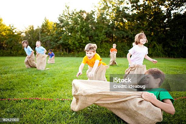 Szczęśliwy Dzieci Uwzględniając Zabawny Ziemniak Wyścig W Worku Poza - zdjęcia stockowe i więcej obrazów Dziecko