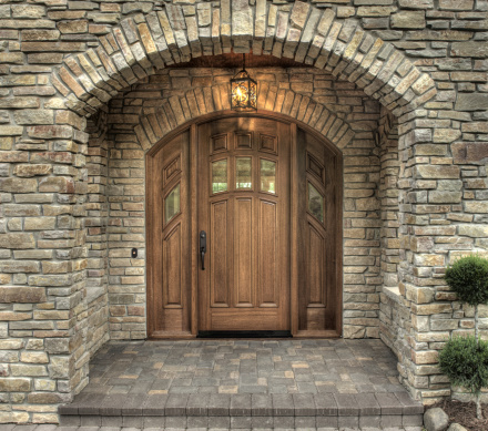 Dramatic stone entry with arch and custom wood door.See more of my interior and exterior home images.