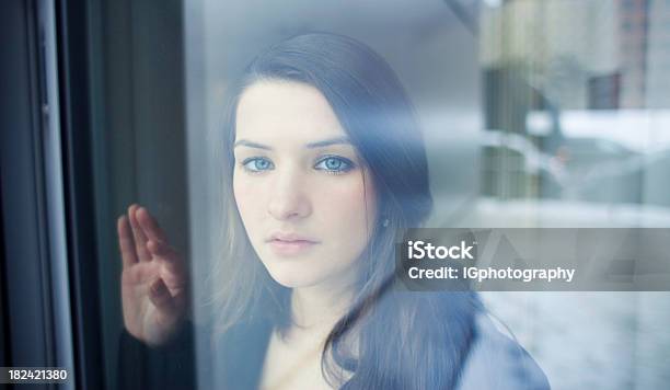 Joven Mujer Mirando Por La Ventana Con Nostalgia Foto de stock y más banco de imágenes de 18-19 años - 18-19 años, 20 a 29 años, Adolescente