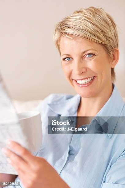 Mujer Feliz Leyendo Un Periódico Mientras Disfruta De Un Café Foto de stock y más banco de imágenes de 30-39 años