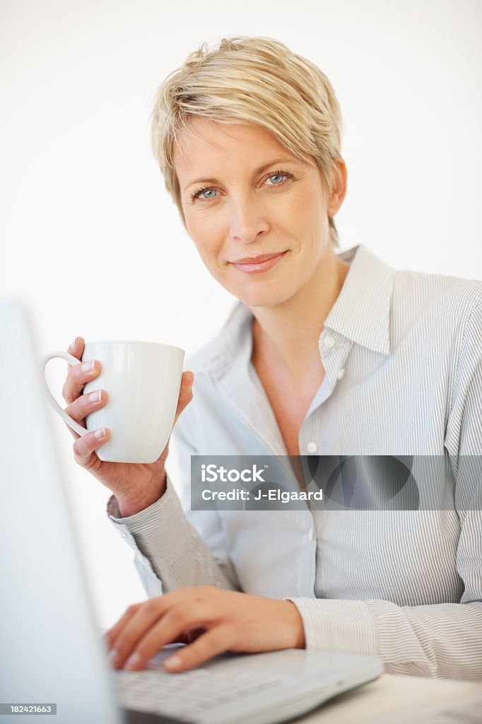 Hermosa mujer de negocios sosteniendo café mientras al trabajar - Foto de stock de 30-39 años libre de derechos