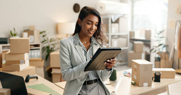 petite entreprise, femme et tablette pour le commerce électronique, la gestion des stocks de la boutique en ligne, de la commande ou du courrier. entrepreneur ou vendeur indien sur la technologie numérique pour la logistique, les boîtes ou les colis - packaging tape photos et images de collection