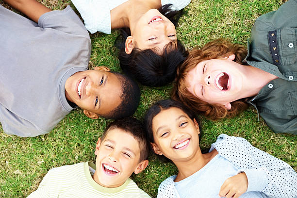 istock Happy young children lying on grass and laughing 182422225