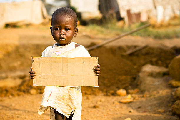 istock African boy holding a blank cardboard sign 182422254
