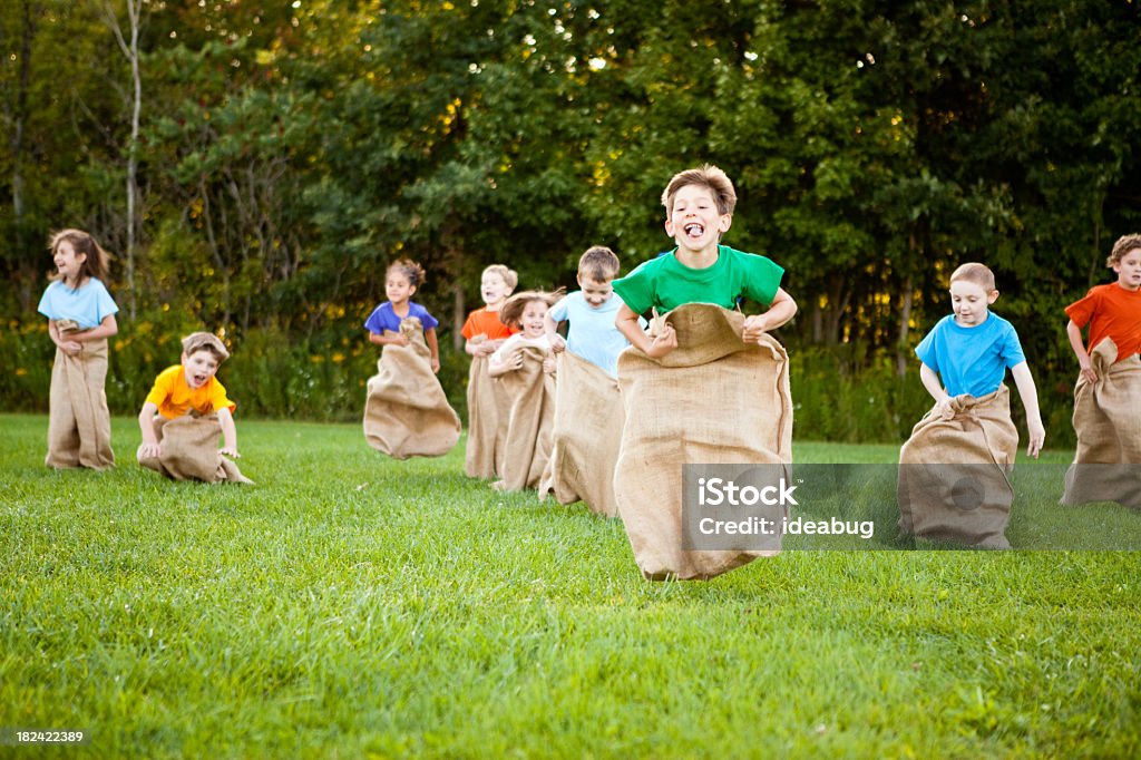 Felice bambini avendo divertimento di patate Corsa col sacco di fuori - Foto stock royalty-free di Corsa col sacco