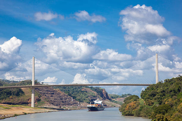 Panama Canal With Cargo Ship Passing Under The Centennial Bridge stock photo