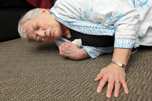 Elderly woman who has fallen onto the floor.