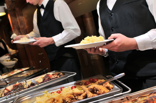 Waiters serving food on wedding or party.