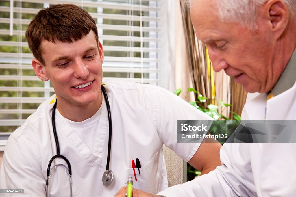 Médico sênior mentoring jovens médicos - Foto de stock de 20 Anos royalty-free