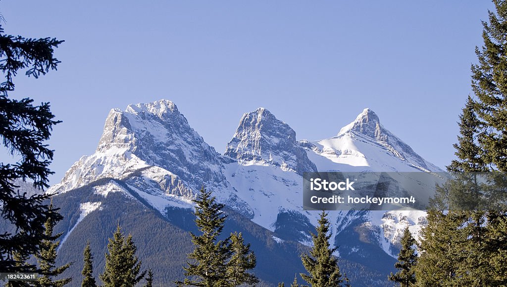 Three Sisters Mountains Canmore Alberta Tree lined view of Three Sisters landmark in Canada. Rocky Mountains Canada Adventure Stock Photo