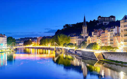 Panoramic view of Lyon with Saint Georges footbridge over Saone river at dusk, France