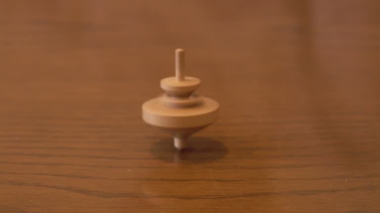 View of spinning wooden top on wooden table