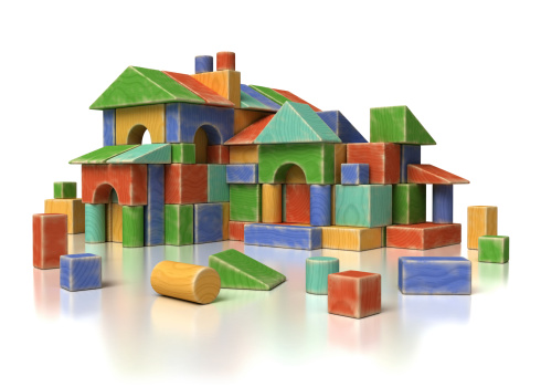 Decorative colorful wooden toy houses stand in a row on a shelf in a gift shop