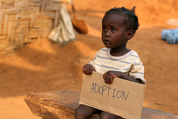 istock African Child Holding Adoption Sign 182424800