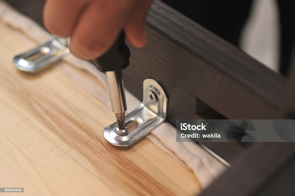 screwdriver human hand uses screwdriver Residential Building Stock Photo