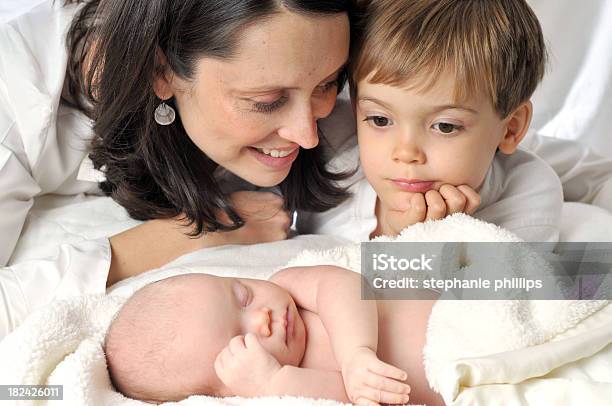 Mother And Son Looking At Sleeping Infant Lying On Bed Stock Photo - Download Image Now