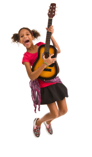 Elementary age female jumping in air and playing guitar