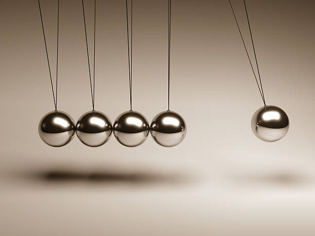 Silver balls on strings in a Newton's cradle The balancing balls Newton's cradle metal sphere stock pictures, royalty-free photos & images