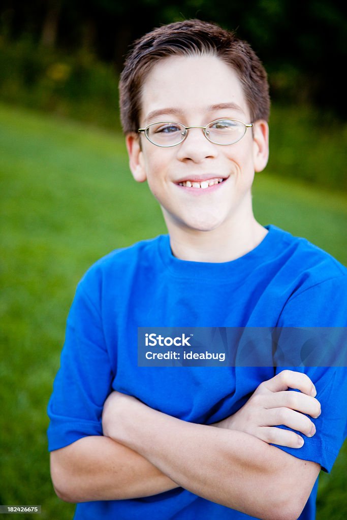 Heureux jeune garçon avec des lunettes souriant à l'extérieur - Photo de 10-11 ans libre de droits