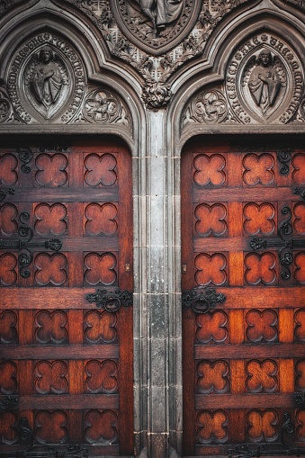 A weathered, vintage wooden door in Edinburgh, Scotland, with a traditional style handle and lock.