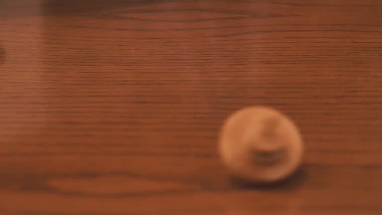 View of spinning wooden top on wooden table