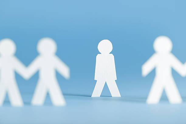 Paper figures holding hands with one alone not participating Paper person not participating in a group activity. On blue. exclusion stock pictures, royalty-free photos & images
