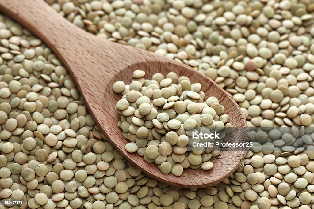 Lentilles vertes dans une cuillère en bois - Photo de Lentille libre de droits