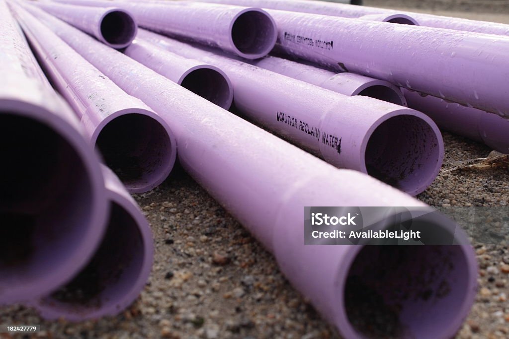 Purple Pipes With Caution Stamp Close up of recycled or reclaimed water pipes used for irrigation. Pipe - Tube Stock Photo