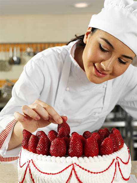 istock Female chef with white strawberry-topped cake 182428453
